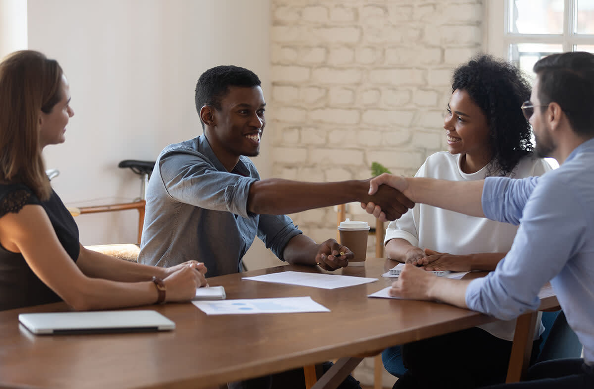 Two people shaking hands during a meeting