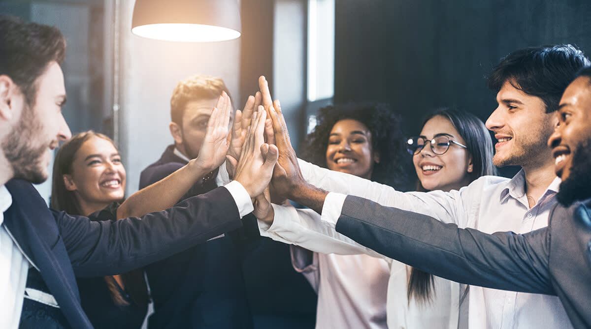 Group of co-workers smiling and high-fiving