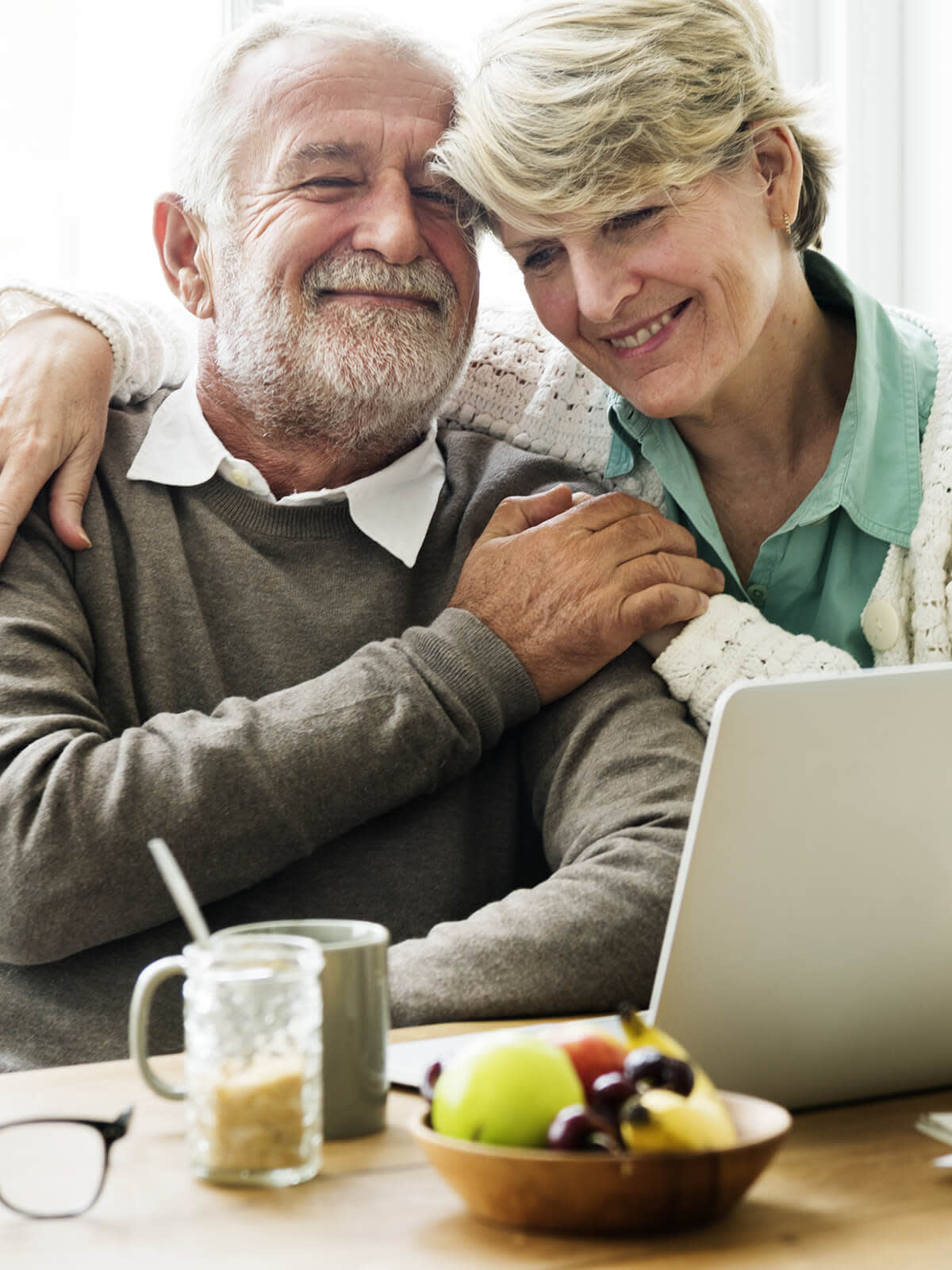 Happy elderly couple looking at laptop