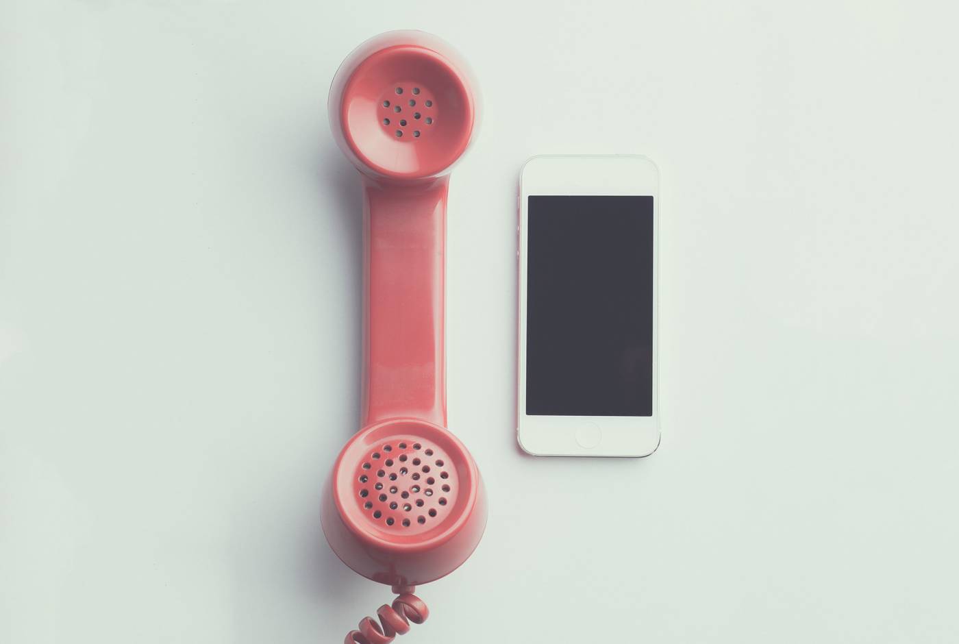 Pink Telephone next to a Cell Phone
