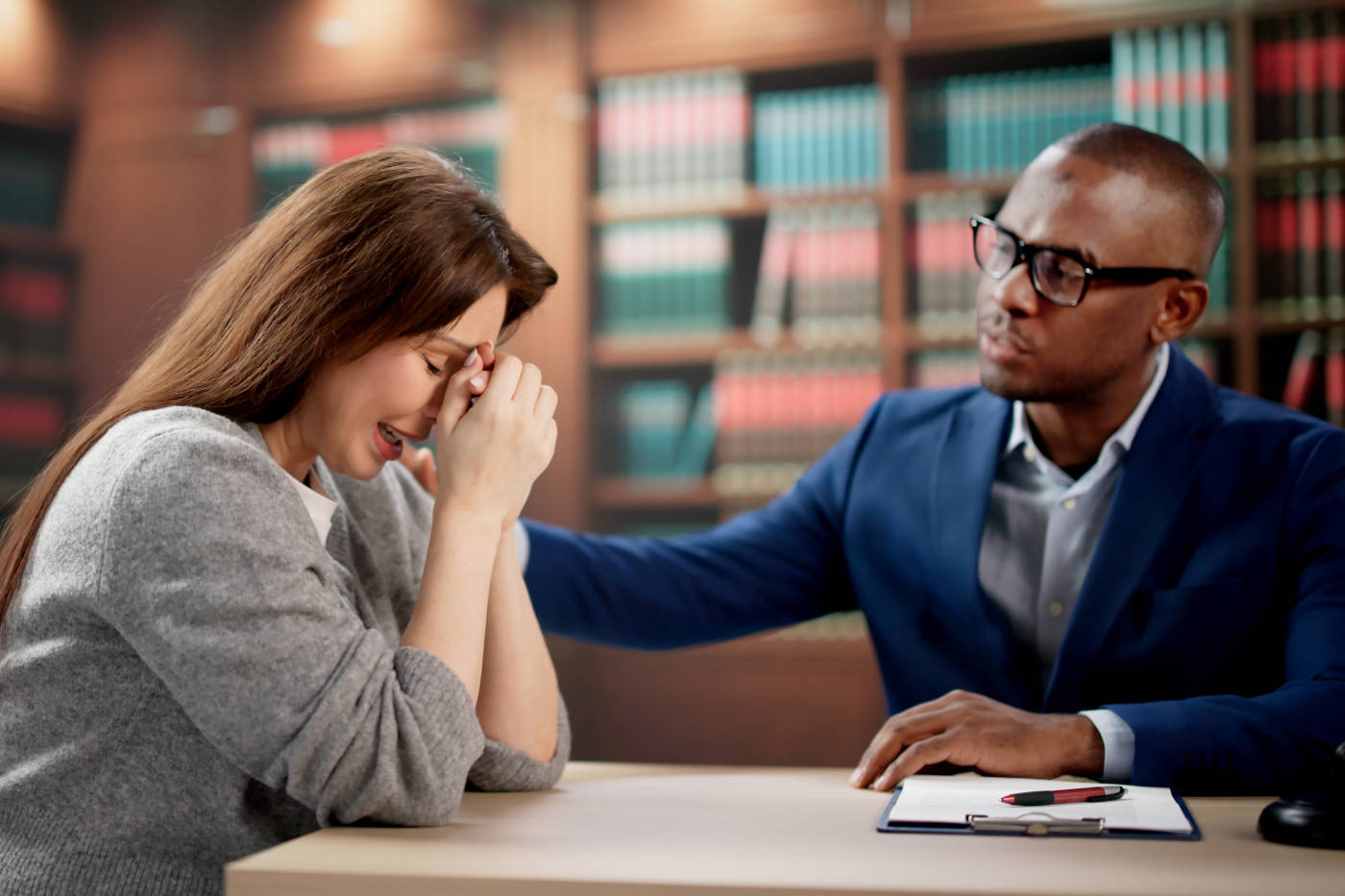 Crying women discussing legal claim with attorney