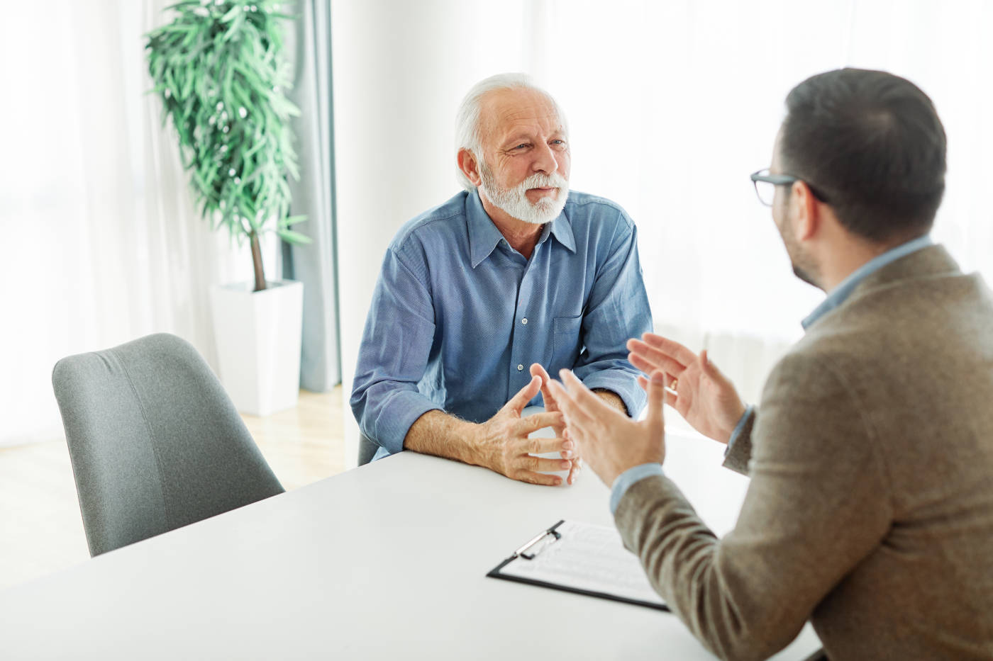 Old man consulting with a professional for Post-Mortem Planning