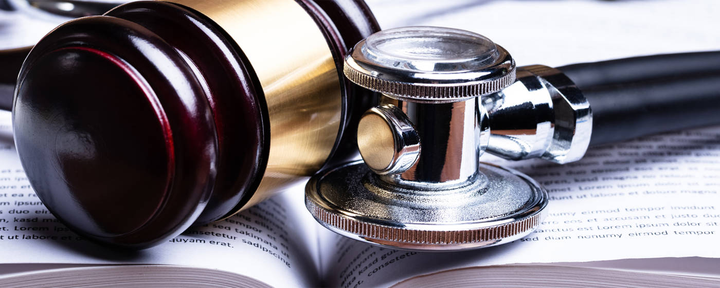 Stethoscope And Mallet Over Open Law Book