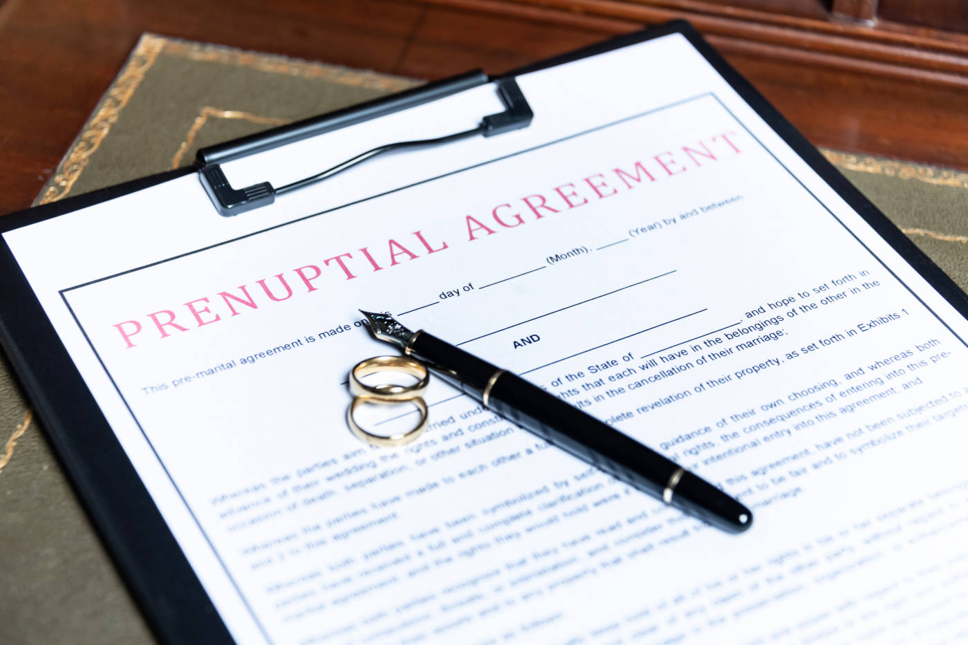 Prenuptial agreement form with wedding ring and pen