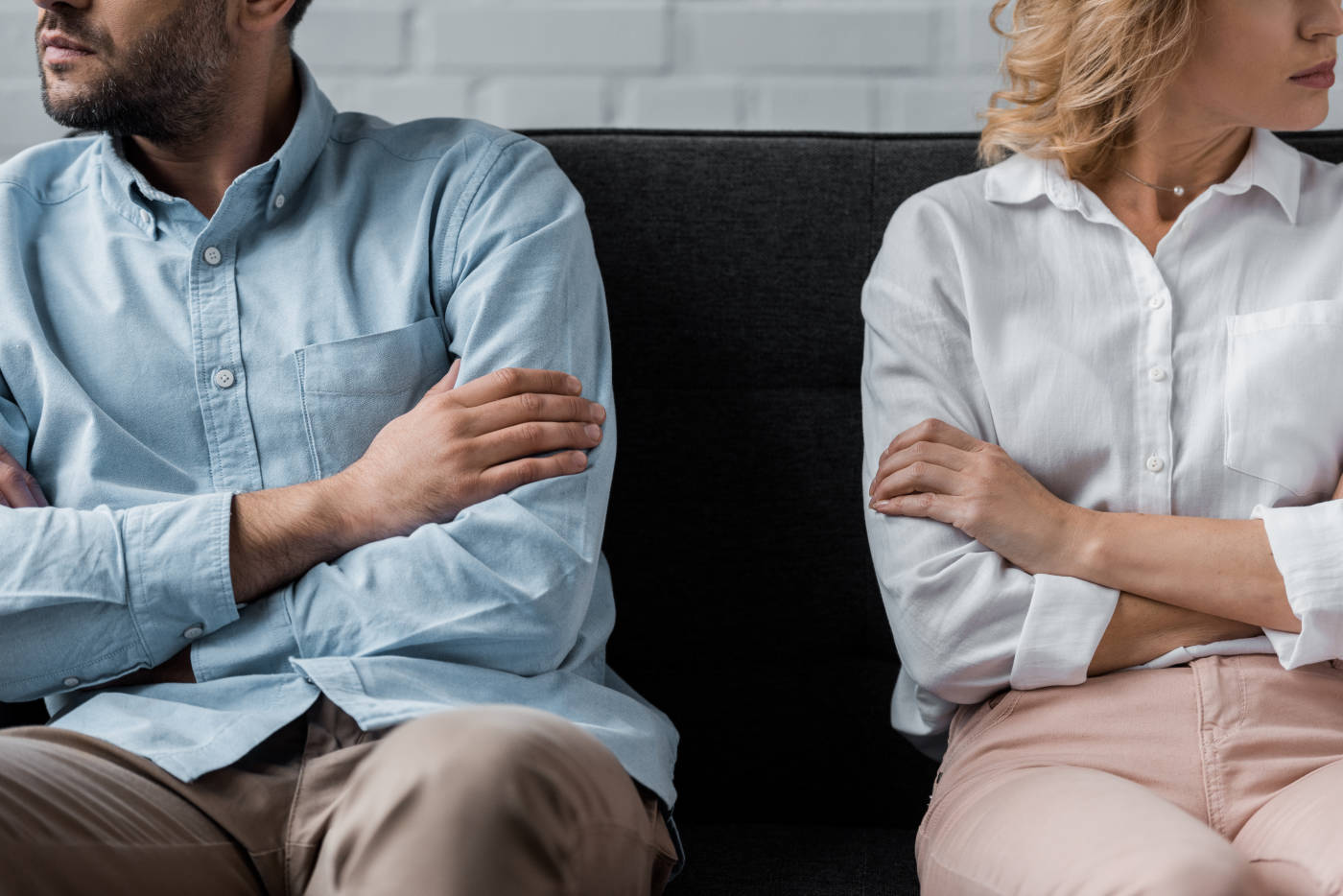 Cropped shot of couple sitting on couch after quarrel.