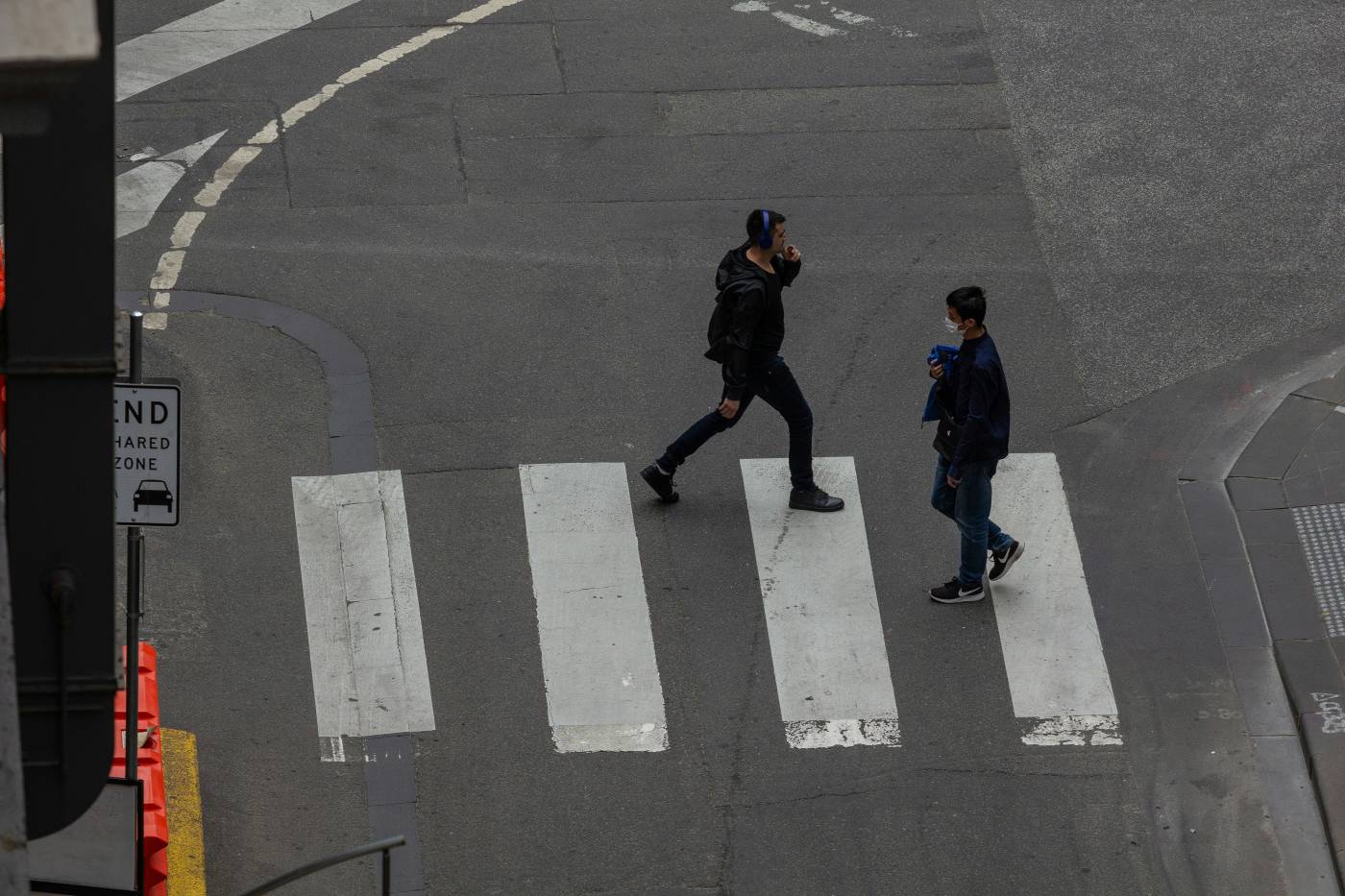 Two male pedestrians crossing the street in an intersection