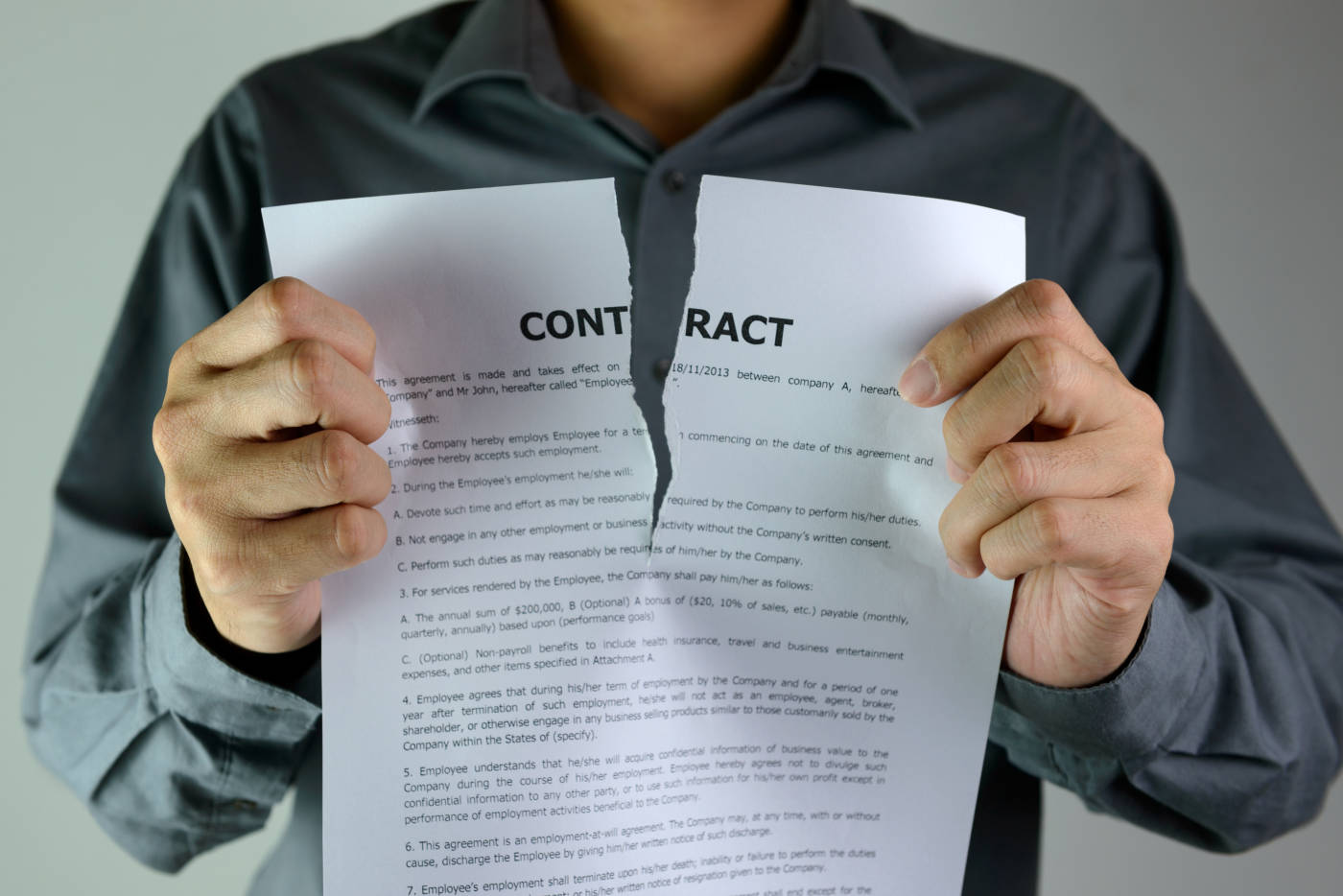 Businessman tearing contract paper in office