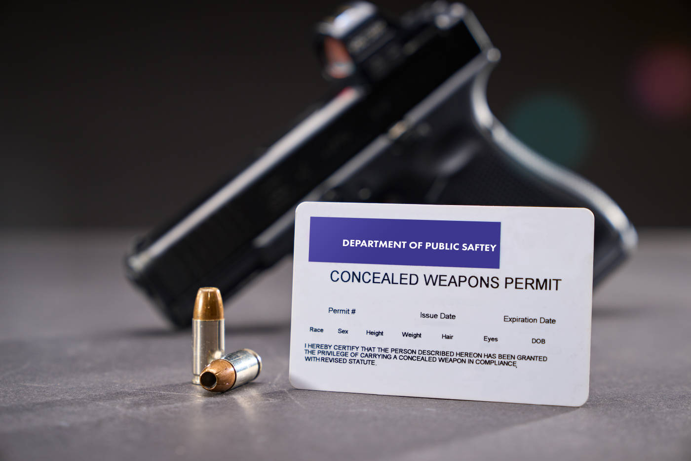 Concealed Carry Permit next to bullets and handgun