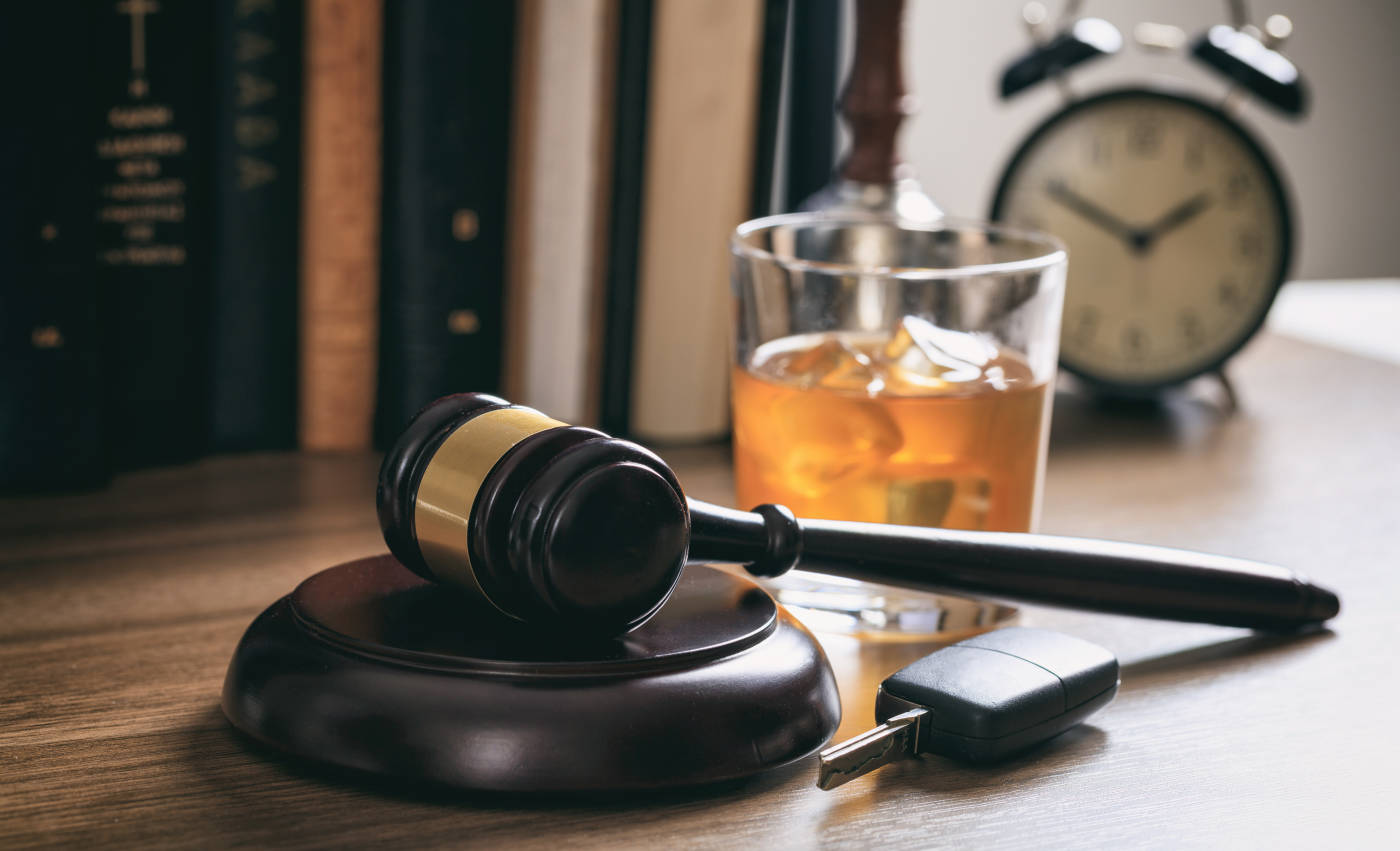 Gavel and glass of alcohol in table