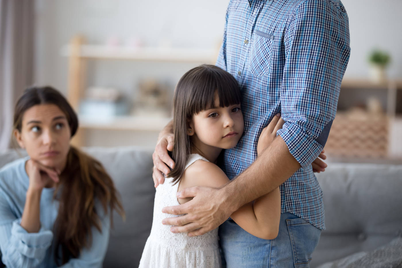 Mother looking at her daughter while she holds on tightly to her father