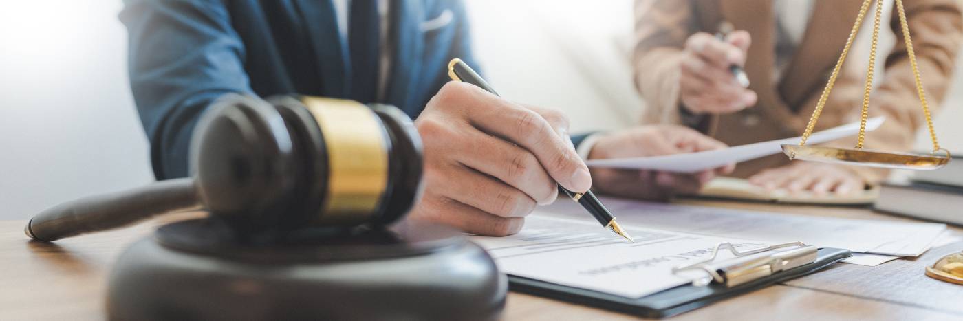 Two men with pens pointing at a document