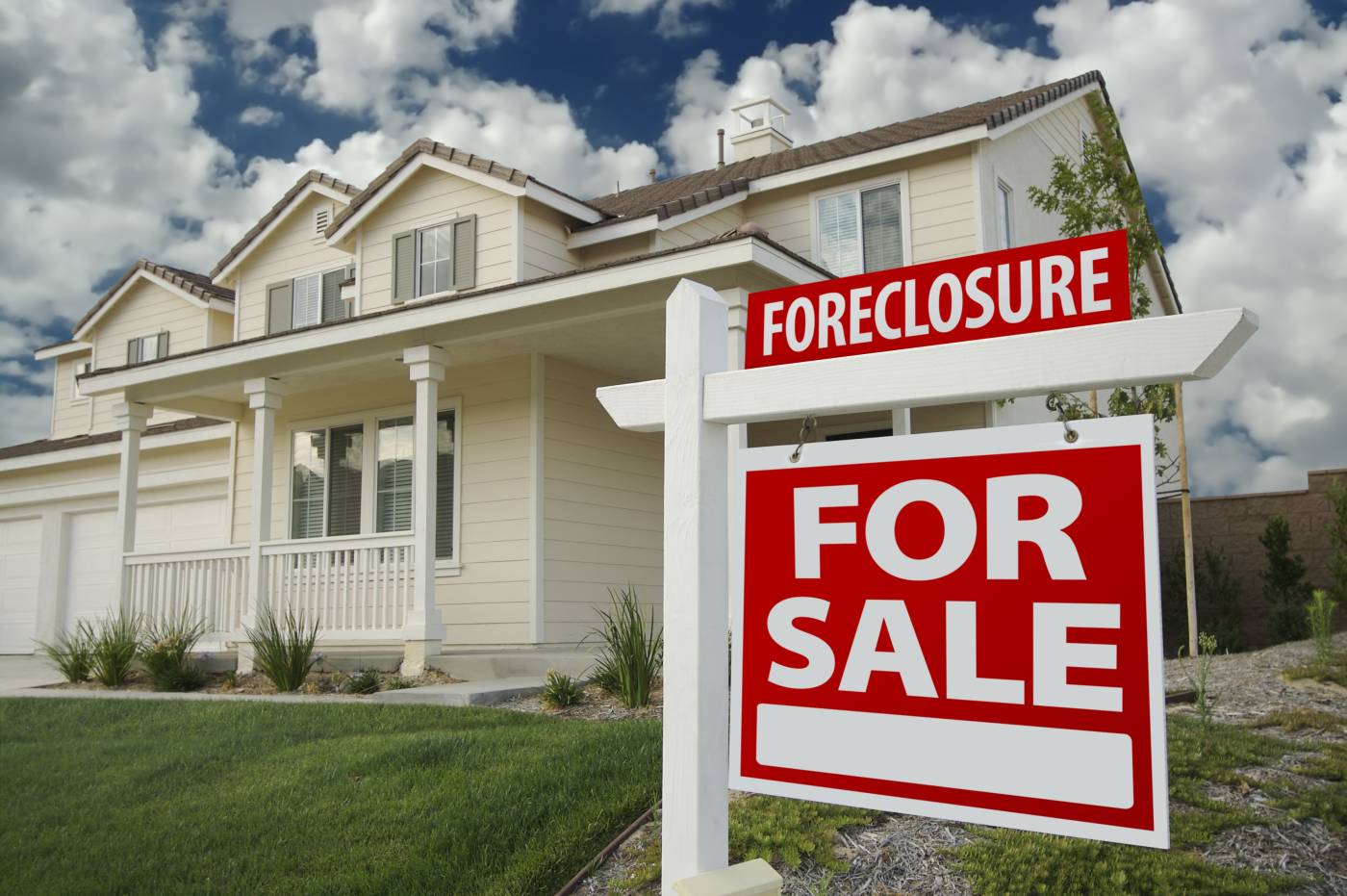 Foreclosure For Sale sign in front of a nice house