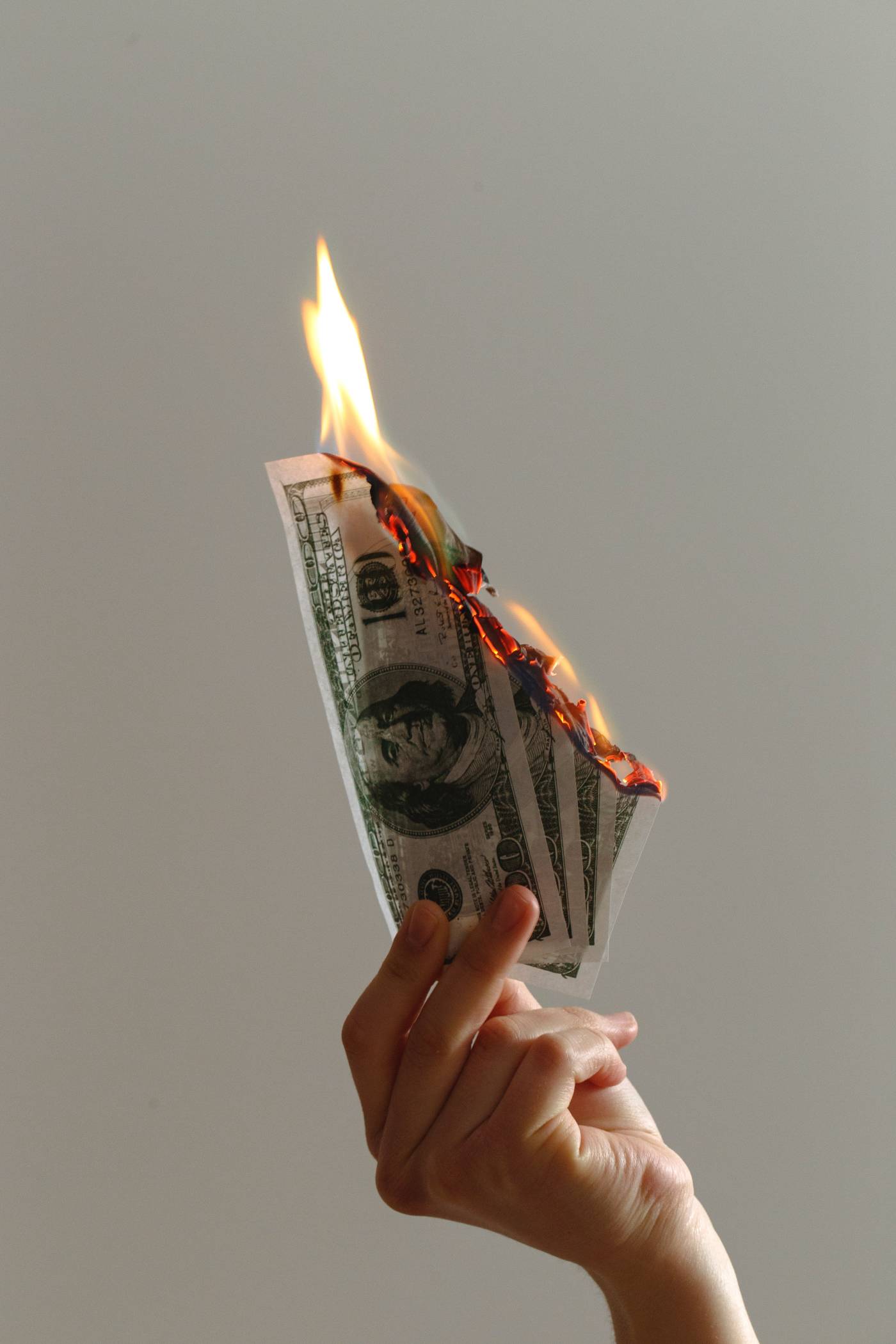 Hands Holding Money Bills on Fire