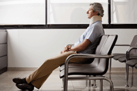 Man in a neckbrace sitting in a waiting room