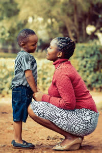 Mother and son smiling at each other while holding hands