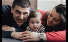 A couple lying down with their baby