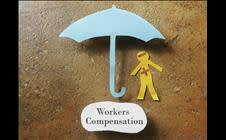 Paper man under a paper umbrella labeled "Workers Compensation" 