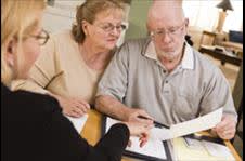 Elderly couple examining documents together with an attorney