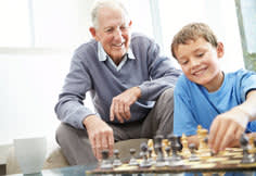 Grandpa watching his son play chess