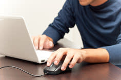 Guy using a laptop with a mouse attachment