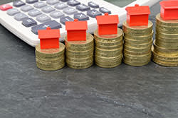 Stacks of coins with toy houses on top