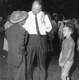 Eight-year-old Mike listens intently to his father console the father of a young man that Boyce had sent to prison as District Attorney 