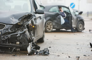 Two cars that look pretty damaged after crashing into each other