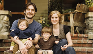 Photo of a family smiling while sitting on porch steps