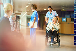 Woman in wheelchair being pushed in a lobby