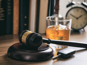 Gavel with a car key and glass of alcohol