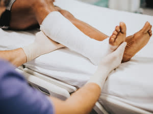 Nurse tending to a patient's leg in a cast