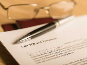 Last will and testament document with glasses and pen