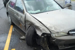 Grey sedan that has been damaged in the front-end