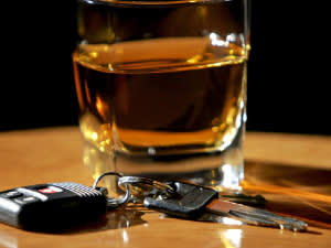 Whiskey glass on table with car keys