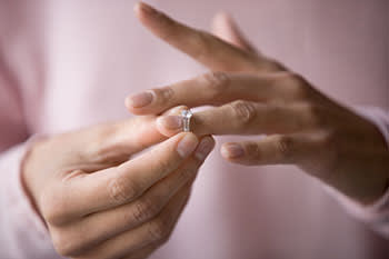 Woman removing diamond ring from her finger