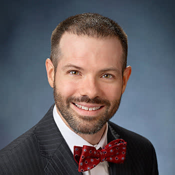 Man smiling with red bow tie