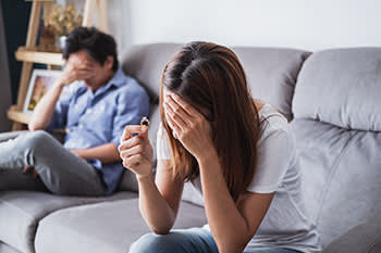 Frustrated couple on the couch reconsidering marriage