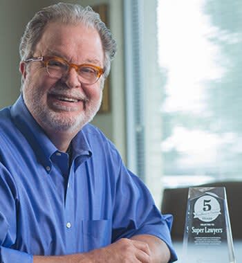 Attorney mike sitting at a table with his award