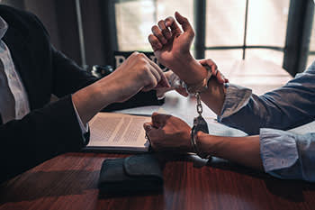 Attorney unlocking man's handcuffs