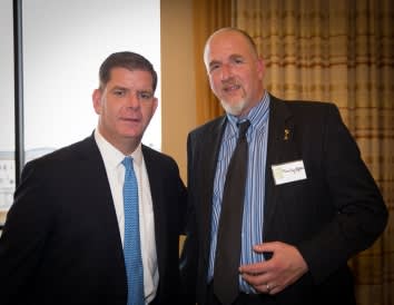 Two men in suits smiling for picture