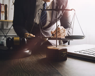 Attorney with gavel, scales of justice, and computer