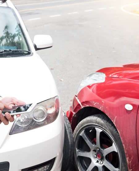 A red and white car touching after an accident