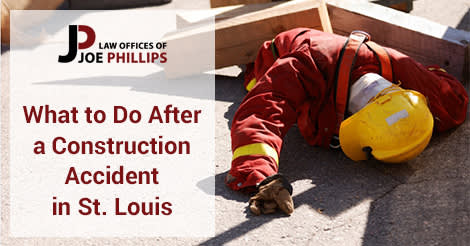 Construction worker laying on ground under wood beams