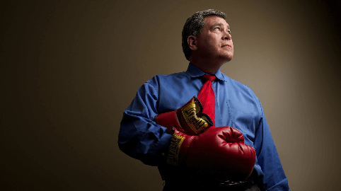 Attorney Ralph Martinez in dress clothes and boxing gloves