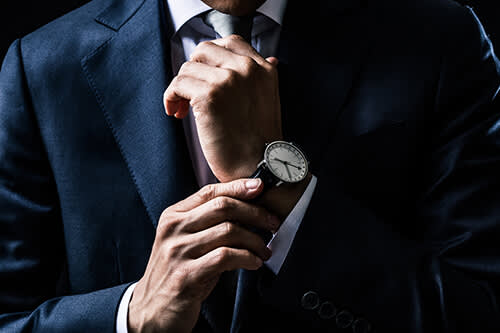 Man in suit adjusting his watch