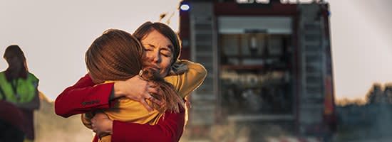 A mother hugs her daughter after a car accident