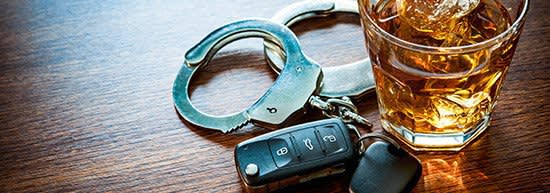 stiff drink alongside car keys and handcuffs