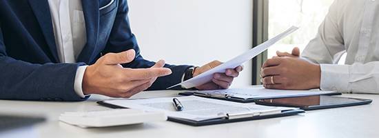 Two men going over paper documents