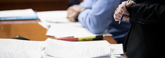 Attorney standing in court with documents on their desk