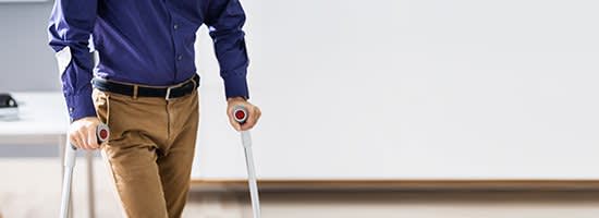 A man walks on crutches